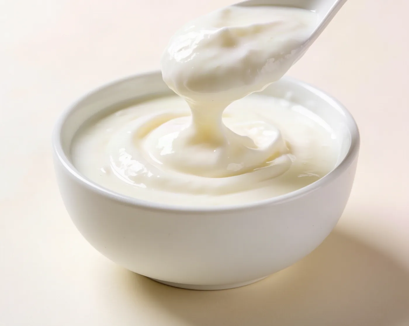 Thick fresh malai (cream) in a white bowl with a spoon